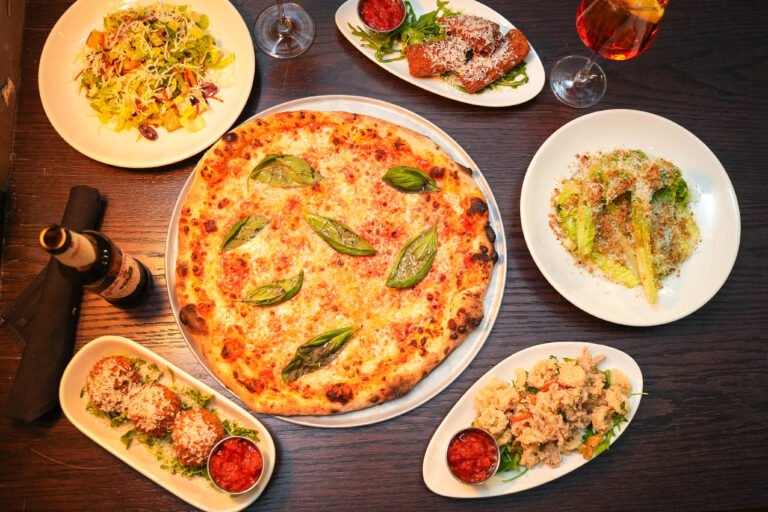 A table filled with Black Dog pizzas and shared plates